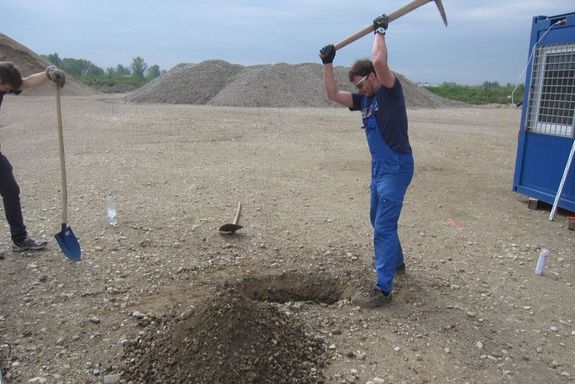 Der Arbeiter auf der Baustelle bearbeitet den Untergrund
