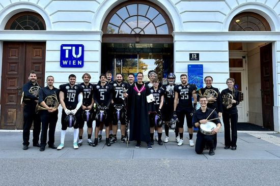 Gruppenfoto TU Orchester, TU Robots und Vizerektorin Grüdling-Riener vor dem hauptgebäude der TU Wien