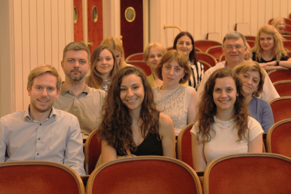[Translate to English:] Visit to the Vienna State Opera. The people are sitting in the auditorium. Armchairs covered with red velvet.