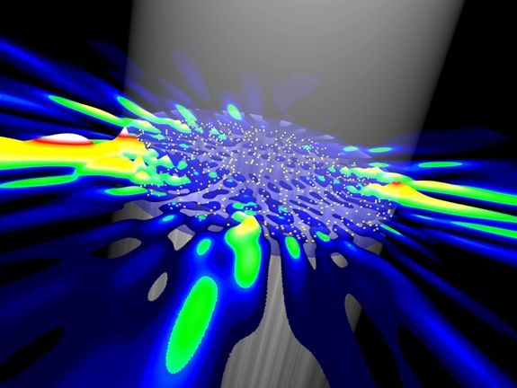 Zufallslaser werden durch einen Lichtstrahl von oben mit Energie versorgt. Zufällige Unregelmäßigkeiten im Inneren (gelbe Punkte) sorgen dafür, dass das Laserlicht in ganz unterschiedliche Richtungen ausgestrahlt wird.