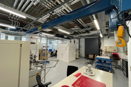 Laborraum der TUW. Rohre an der Decke sichtbar, Schreibtisch im Vordergrund.