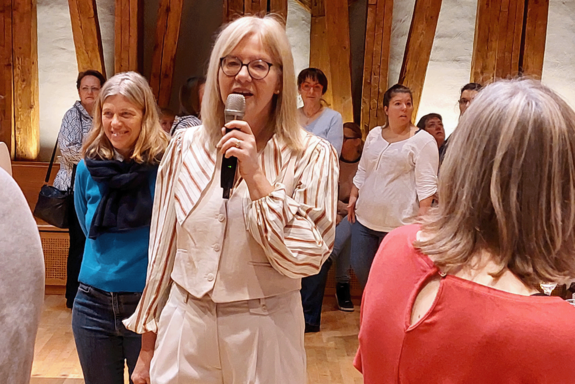 Vizerektorin Anna Steiger mit weißem Hosenanzug und Mikrofon.