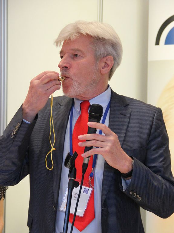 [Translate to English:] Prof. Ewald Benes bei der Demonstration der Lautstärke und des Obertonreichtums (mit hohen Ultraschall-Anteil) der goldenen Tritone Samba Thriller Pfeife