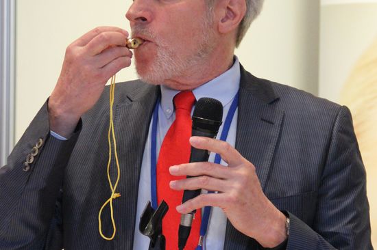 [Translate to English:] Prof. Ewald Benes bei der Demonstration der Lautstärke und des Obertonreichtums (mit hohen Ultraschall-Anteil) der goldenen Tritone Samba Thriller Pfeife