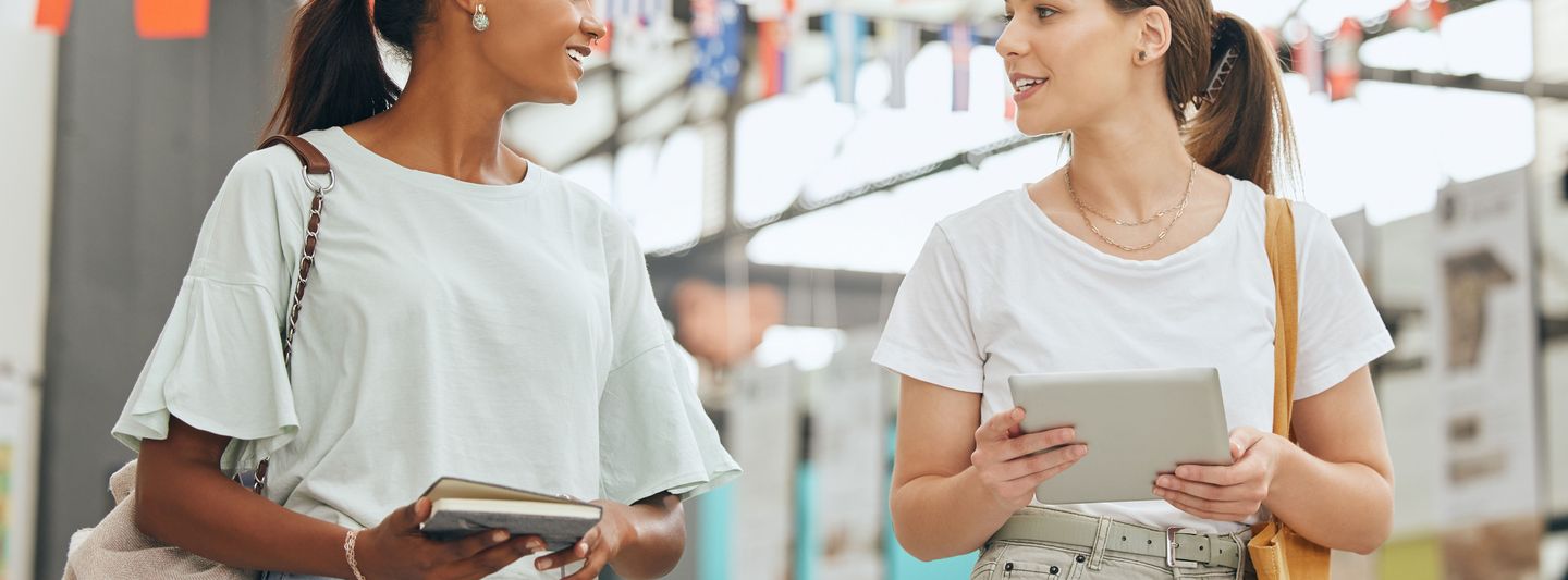 Zwei Studierende unterhalten sich bei einer Messe.