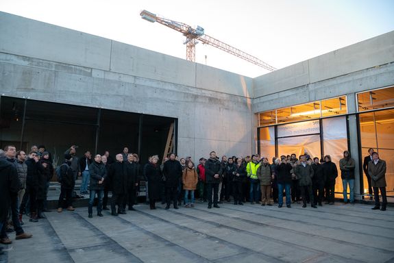 Auf der Terrasse des neuen Laborgebäudes wird von Seiten der Baufirma der launige Richtspruch gesprochen.