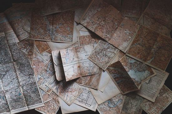 alte, teils vergilbte Karten verteilt auf einem Tisch