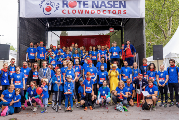 Gruppenfoto der TU Wien-Starterinnen mit blauen T-Shirts auf der Bühne des Rote Nasen Laufs.