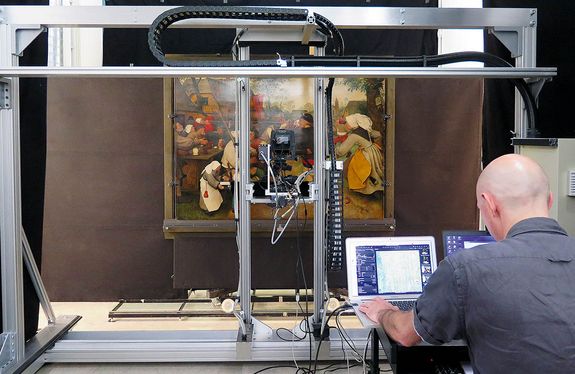 Historisches Bild wird gescannt, ein Mitarbeiter überwacht den Vorgang an einem Laptop.