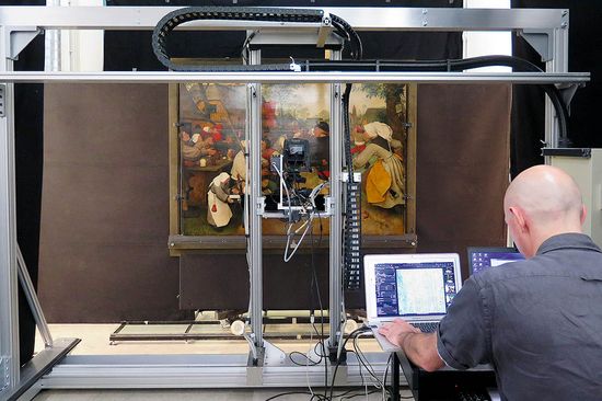 Historisches Bild wird gescannt, ein Mitarbeiter überwacht den Vorgang an einem Laptop.