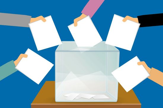 Illustration die Hände mit Wahlzetteln an einer Wahlurne zeigt