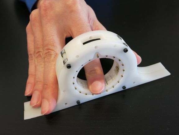 An der Innenseite wird die Braille-Schrift mit einem Finger abgelesen. An der Innenseite wird die Braille-Schrift mit einem Finger abgelesen.