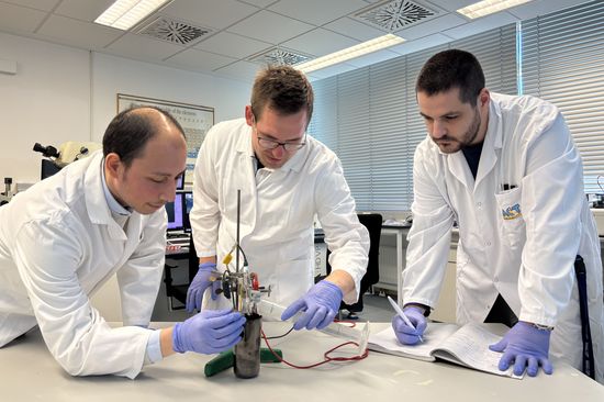 three scientists in white lab coats