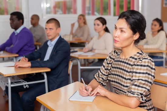 Mehrere Personen unterschiedlicher Herkunft sitzen zusammen in einem Deutschkurs