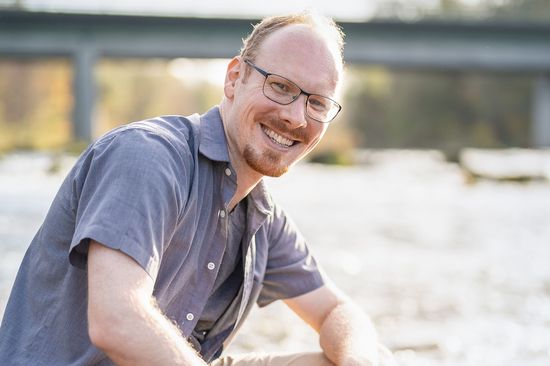 ECR-Grant winner Andreas Schindewolf sitting bei a river.