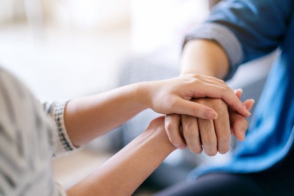 Zwei Hände, die eine andere halten.