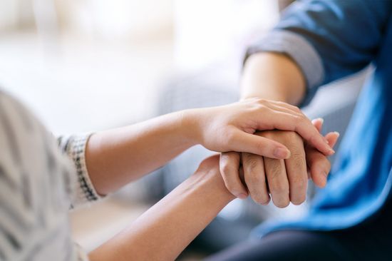 Zwei Hände, die eine andere halten.