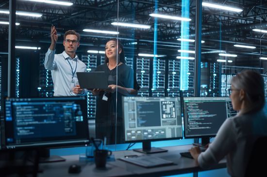 A man explains the equipment in a technical laboratory to a new female colleague. 