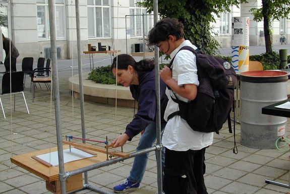 Ausstellungsbesucher beim Ausprobieren eines Versuches