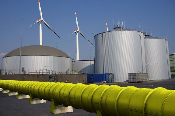 Vordergrund, gelbe Pipeline – Vordergrund, Windräder und Raffinerie