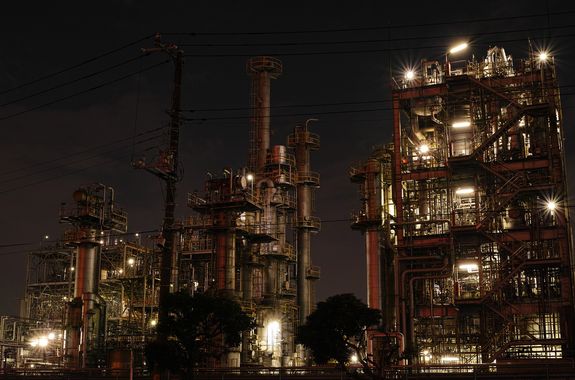 Symbolbild: Fabrik/Raffinerie bei Nacht mit vielen Lichtern.