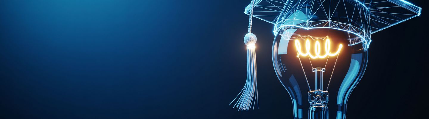 Leuchtende Glühbirne mit Abschlusskappe als Symbol für Bildung und Innovation