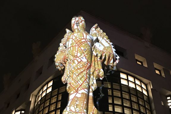 Light installation with images projected on the library building and owl sculpture