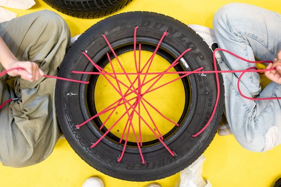 Autoreifen mit Löchern und roten Schnüren bespannt