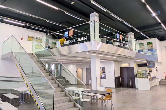 staircase on the left side that lead to a galery with tables and chairs