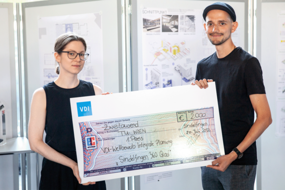 Zwei Personen halten einen überdimensionalen Scheck hoch.