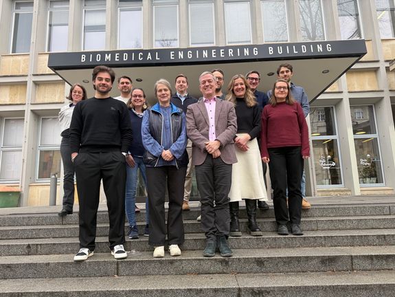 Gruppenfoto auf der Stiege vor dem Gebäudeeingang mit Studierenden, Lehrgangsleiter und Vortragenden des ULG Nachhaltiges Bauen