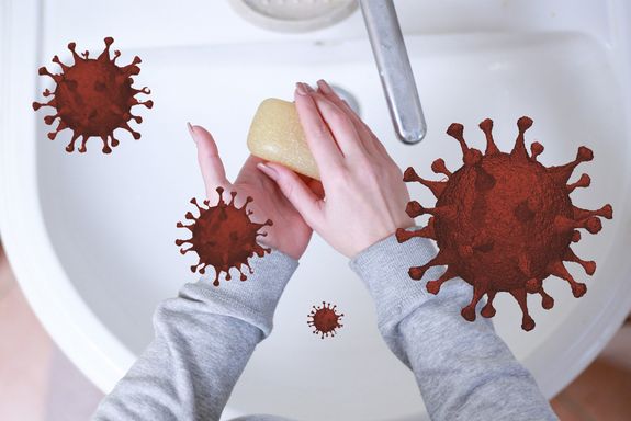 Händewaschen mit Seife von oben fotografiert. Stark vergrößert rundherum grafisch dargestellte rote Coronaviren mit Spikes zum Andocken. 