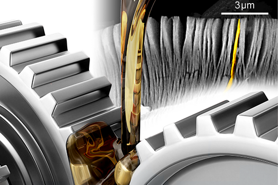 Im Vordergrund: Zahnräder, auf die Öl zur Schmierung gegossen wird. Im Hintergrund: Abbildung von 2D-Material.