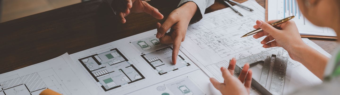 Architects and engineers discussing over building project blueprint in meeting room