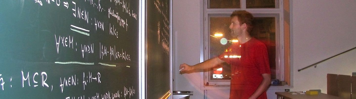 One person writes formulas on the board