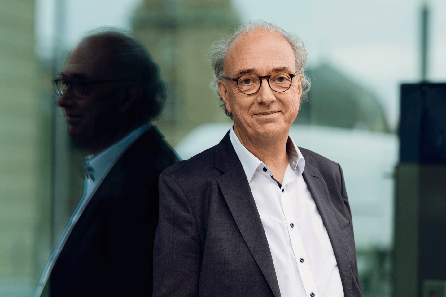 Porträtbild Johannes Buchmann. Er trägt ein Sakko und ein weißes Hemd.