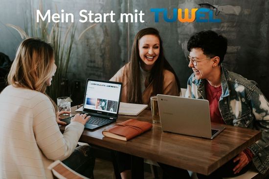 drei Studierende mit Laptops, beim Tisch sitzend