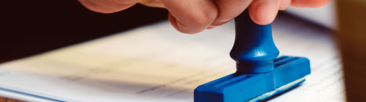A hand affixing a stamp