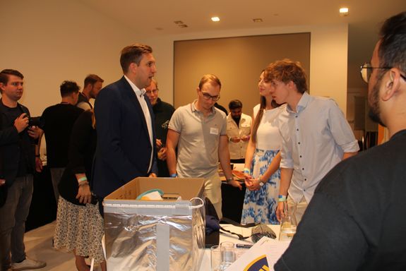 Tische, Menschen stehend und im Gespräch