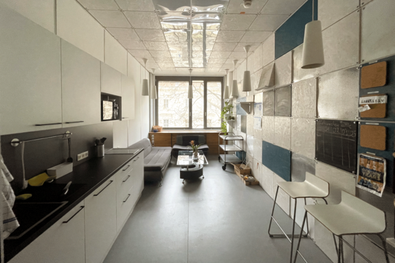 Moderne schmale Küchenzeile in Schwarz-Weiß, Couch und Fenster am hinteren Ende.