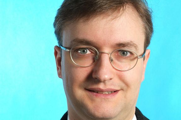 Christoph Grimm Portrait photo of Christoph Grimm on the bright blue background