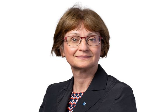 Brustbild von Vizerektorin Ute Koch mit schwarzem Blazer und rot-blau-weiß gemustertem Unterteil. Sie trägt einen Pagenkopf. Weißer Hintergrund.