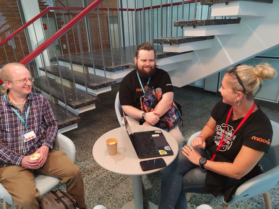 [Translate to English:] 3 Leuten an einem Tisch sitzend