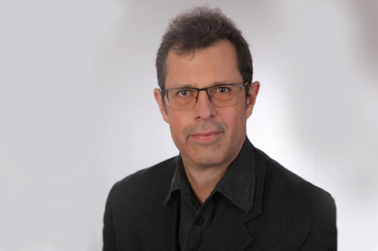 Porträtbild in Farbe mit hellem Hintergrund.