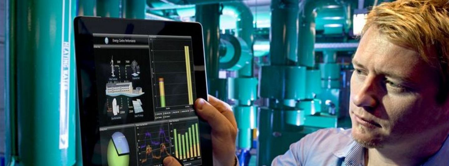 Mitarbeiter bedient ein Tablet in einer futuristisch anmutenden Fabrik