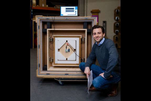 Markus Fallmann kneels next to the newly developed transport box.