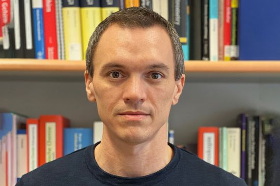 Hannes Mikula vor einem Bücherregal