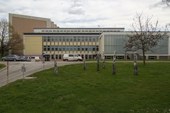 Atominstitut Frontansicht Fassadenansicht. Im Erdgeschoss die Außenwände bestehen aus Ziegel. Zwei obere Stockwerke sind in zwei Farben ausgeführt (gelb und grau).