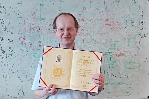 Joachim Burgdörfer mit der Verleihungsurkunde der Ehrenprofessur