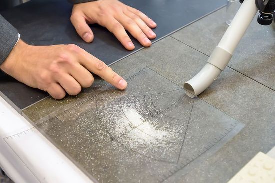 Image Left: The pattern of scattered material shows the slip resistance class of the floor. Right:  Prototype of the TU Wien floor slip tester with a height of about 20 cm - Metal holder with inclined glass tube approx. 35cm long, through which water can be channelled to the floor.  Link to PDF "FLOOR SLIP TESTER FOR EASY IN-SITU TESTING" 